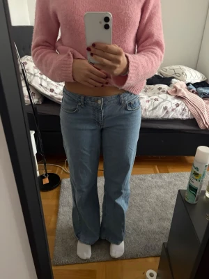 Ljusblå  jeans - Säljer ett par ljusblå bootcut jeans med klassisk femficksmodell och låg midja. Jeansen har raka ben som blir vidare nedtill och är tillverkade i ett mjukt denimtyg. Perfekta för en avslappnad och trendig look.