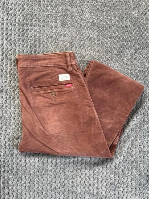 Levis’s manchesterbyxor  - Säljer ett par bruna manchesterbyxor från Levi's med klassisk femficksmodell och smal passform. Byxorna har en bakficka med knapp och den ikoniska röda Levi's-lappen. Tillverkade i mjuk manchester för en retro och avslappnad look.
