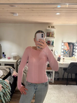 Ljusrosa långärmad topp från Stories - Supersöt ljusrosa långärmad topp från Stories i tunn och mjuk bomull. Modellen är figurnära med rundad halsringning och passar perfekt till jeans eller kjol. Enkel men stilren design som är lätt att matcha.