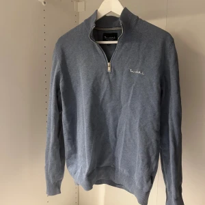 Bondelid tröja - Snygg blå tröja från Bondelid, med halv dragkedja och ståkrage. Broderad logga på bröstet. Perfekt att matcha med jeans. Hör av dig vid minsta lilla fundering! 