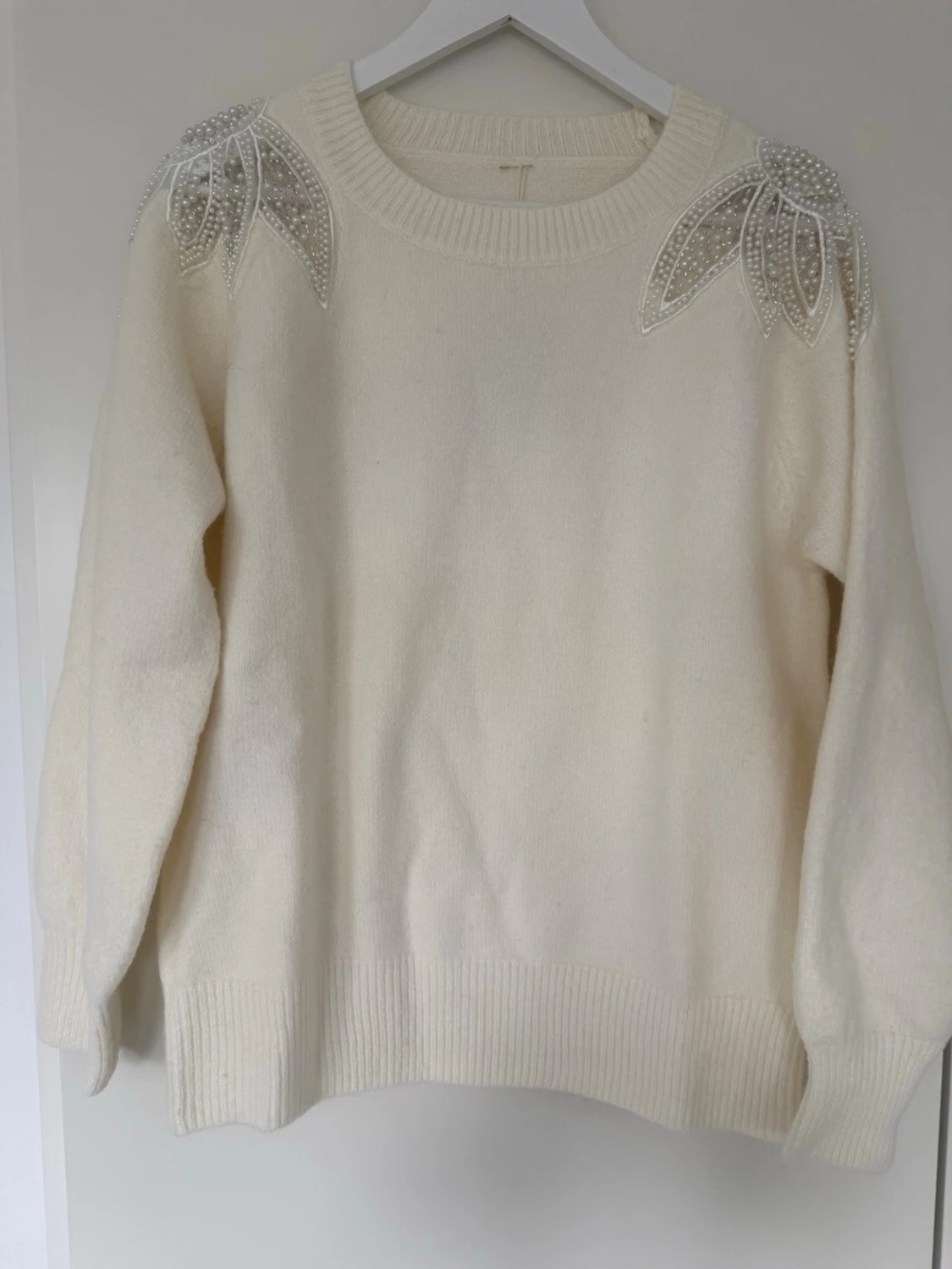 Vit stickad tröja med pärldetaljer