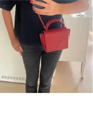 Röd ATP väska - Snygg röd handväska från ATP. Bra skick lite slitningar i färgen men inget man tänker på. Skulle söga att man får plats med mer än vad man tror. Så snygg till alla typer av outfits