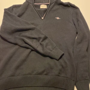 Svart tröja med dragkedja från Gant - Säljer en snygg svart tröja från Gant i storlek L men passar även bra som M!Perfekt för både vardag och lite finare tillfällen. Tröjan är i mycket bra skick och redo för en ny ägare!