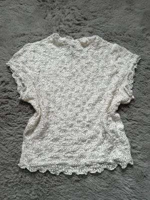 Vit spetstopp från hm - Söt vit blus i spets med blommigt mönster och vågig kant nertill. 