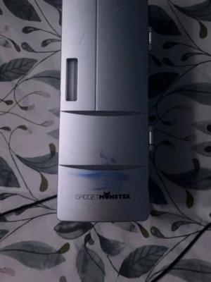 GadgetMonster minikyl - Säljer en silverfärgad minikyl från GadgetMonster. Den har en rektangulär form med lucka och fönster på framsidan. Perfekt för att kyla ner din fredagsdricka