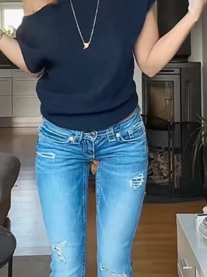 Mörkblå stickad topp - En enkel och stilren mörkblå stickad topp med korta ärmar och rund hals. Toppen har en loose passform och är perfekt att matcha med jeans eller kjol för en avslappnad look.