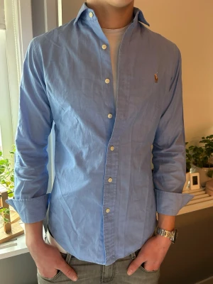 Blå skjorta från Ralph Lauren - Klassisk ljusblå skjorta från Ralph Lauren. Storlek S. Modellen är 186cm 73kg