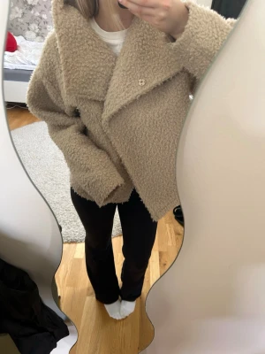 Beige oversized teddyjacka - Mysig och trendig teddyjacka i beige med oversized passform och stora slag. Jackan har en knäppning framtill och är gjord i fluffigt, mjukt material som ger en cool och avslappnad look. Jackan är ifrån Ginatricot och i stl xs, väldigt fint skick💕