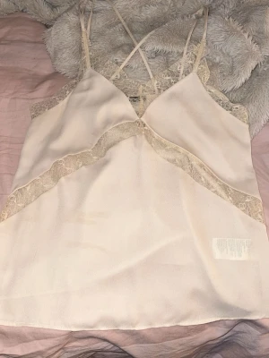 Beige spetslinne med tunna axelband - Jätte fint linne ifrån bikbok,aldrig använd. Kom gärna med pris förslag!💕💕