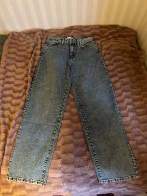 Blå raka jeans från Perfect Jeans - Säljer ett par klassiska blå raka jeans från Perfect Jeans i storlek 32. Jeansen har hög midja, bälteshällor och femficksmodell. Tillverkade i slitstark denim med snygg tvättad look. Perfekta till en avslappnad stil.