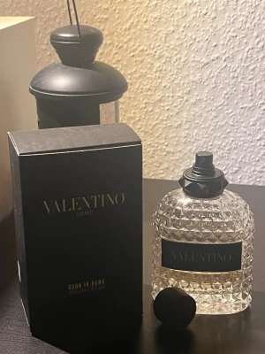 Valentino Uomo Born In Roma Yellow Dream - Exklusiv parfym från Valentino 100ml 50% kvar, Uomo Born In Roma Yellow Dream. Flaskan är transparent med nitar och svart etikett, och kommer med originalkartong. Lyxig design i glas med svart spraykork. Perfekt för dig som gillar eleganta dofter.