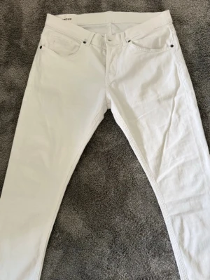 Dondup George vita - Säljer ett par supersnygga vita Dondup. Perfekt för dig som vill ha ett par kvalitetsjeans med grym passform. Skick 9/10. Stl. W34 (sitter som W33). Midja bredd: 40cm, lår bredd 25cm, ytterlängd: 90cm, innerlängd: 65cm