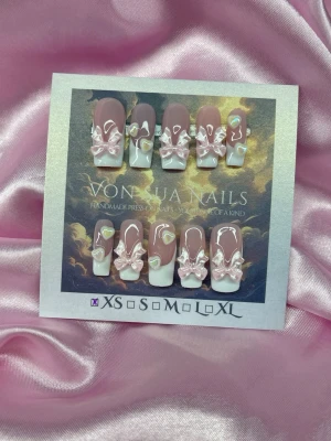 Bby (XS);Medium Square - Superfina handgjorda press-on naglar i square form. Naglarna är ljusrosa med vit fransk tipp, dekorerade med 3D-rosetter och små pärlformade hjärtan. Perfekt för dig som vill ha en söt och unik nageldesign. Handgjorda och detaljerade.XS: 14 mm, 11 mm, 11,5 mm, 10 mm, 8 mm 