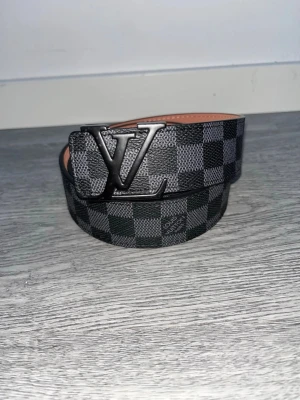 L-bälte  - Snygg bälte ifrån L i färgen svart och monogram mönster runt hela bältet. Storlek:110 cm