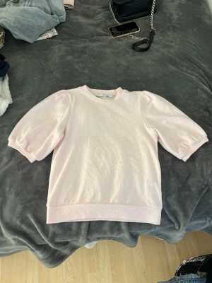 Rosa T-shirt  - En fin rosa topp med pösiga ärmar och skönt material, använd fåtal gånger och är i princip i ny skick, skriv vid fler frågor 