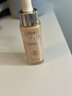 L'Oréal True Match Nude Tinted Serum - Ljusbeige foundation-serum från L'Oréal Paris, True Match Nude Plumping Tinted Serum med 1% hyaluronsyra. Kommer i glasflaska med pipett och ger en naturlig, återfuktande finish. Nyansen är 0.5-2 Very Light, perfekt för en fräsch och lätt täckning. Ungefär 60% kvar! 