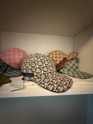 Ferragamo keps  - Säljer en svart/beige keps från Ferragamo med ett grafiskt mönster och justerbar rem bak. Kepsen har en böjd skärm och är tillverkad i ett slitstarkt tygmaterial. Perfekt för dig som vill sticka ut med en unik accessoar.