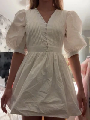 Studentklänning  - Vit miniklänning från showpo, men köpt på sellpy. Klänningen e perfekt för studenten 🥰 På sista bilderna kan man se att de finns väldigt lätta fläckar på ryggen. 