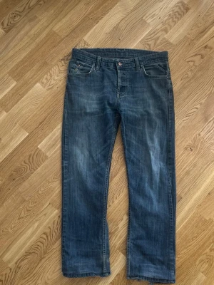 Diesel jeans – uppsydda (custom längd) - Säljer ett par snygga Diesel jeans i blå tvätt. Byxorna är uppsydda i längden och har en rå/avklippt nederkant med lite “heelbite” (slitage längst ner bak vid hälen), vilket ger en cool och använd look.  Mått:  * Längd: ca 104 cm * Midja: ca 44 cm (platt mätt)  Fint skick i övrigt med naturligt slitage som syns på bilderna. Perfekta vardagsjeans med skön passform.