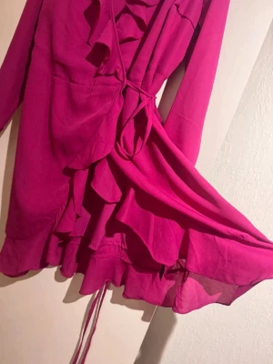 Fin klänning - Vacker cerise rosa klänning till fest!💃🏻 Omlott med volanger och knyt i midjan för justerbar passform. Nyskick!🥰👌