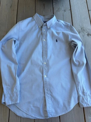 Skjorta från Ralph Lauren - Klassisk ljusblå skjorta från Ralph Lauren. Inga defekter alls, inprincip nytt skick. Storlek S perfekt till sommaren! Hör av dig vid frågor! Pris går att diskutera vid snabb affär!
