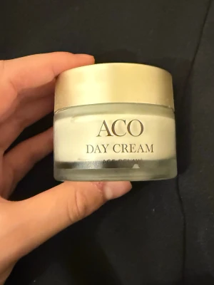 ACO Day Cream med SPF 15 - ACO Day Cream är en ansiktskräm i glasburk med guldfärgat lock. Krämen innehåller sheasmör och ceramid, och har SPF 15 för extra skydd. Passar för dig som vill ha återfuktad och strålande hud. Använt fåtal gånger.