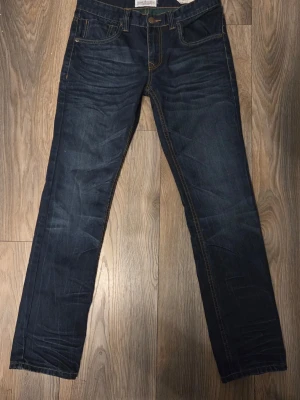 Mörkblå raka jeans med kontrastsömmar - “Stilrena mörkblå jeans från Shine Original i modellen Harlem (straight fit / tapered legs). Bra skick, snygg passform och skön kvalitet. Passar perfekt till vardag eller skola. Snabb affär prioriteras  W32: ca 82cm Midja  L32: ca 81 cm innerben  Lårbredd: ca 23-24cm Benöppning ca 18cm  Pris kan diskuteras