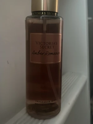 Victoria's Secret Amber Romance mist - En lyxig body mist från Victoria's Secret Amber Romance. Flaskan är transparent med en varm bärnstensfärgad vätska och har guldfärgad kork. Men har använt. Perfekt för dig som gillar söta och sensuella dofter. 