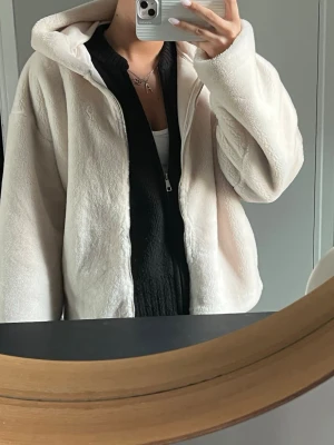 Vit teddyjacka med huva - Mysig vit teddyjacka med dragkedja och stor huva. Jackan har en oversized passform och är gjord i fluffigt, mjukt material. Storlek M men passar som S🤍