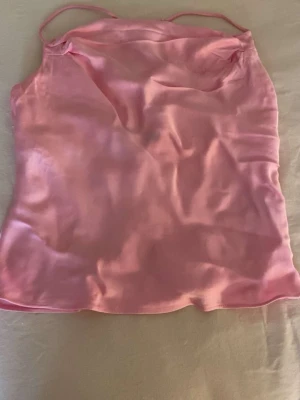 Rosa satin linnetopp med tunna band ifrån Zara💓 - En rosa linnetopp i satin med tunna axelband som korsas i ryggen. Toppen har en slät, glansig yta. Den är lite öppen i ryggen också💓, den är ifrån Zara i storlek s