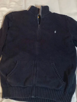 🔥 Ralph Lauren Zip Knit – Clean och stilren  - Säljer en grå Ralph Lauren zip-up knit i riktigt snyggt skick. Sjukt clean modell med den klassiska blå RL-loggan som passar perfekt till jeans, cargos eller chinos.  ✅ Stilren & lätt att matcha ✅ Skön och varm kvalitet ✅ Perfekt till vardag/skola ✅ Inga konstiga slitningar eller fläckar  Ger verkligen en clean old money-look som många vill ha just nu 👌  📦 BONUS: Slänger även med en liten överraskning i paketet 👀  Först till kvarn 🔥