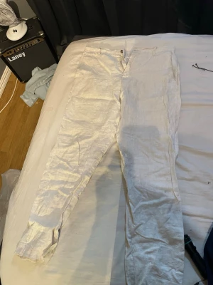 Ljusbeige linnebyxor från Zara  - Snygga vita linnebyxor med rak passform och klassisk midja. Byxorna har dragkedja och knapp framtill samt sidfickor. Perfekta för en avslappnad och stilren look. Tillverkade i svalt och luftigt linne.