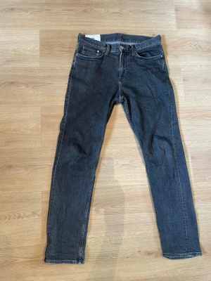 Svarta slim fit jeans - Snygga svarta slim fit jeans med klassisk femficksdesign och dragkedjegylf. Jeansen har raka ben och diskreta sömmar, perfekta för en stilren look. 