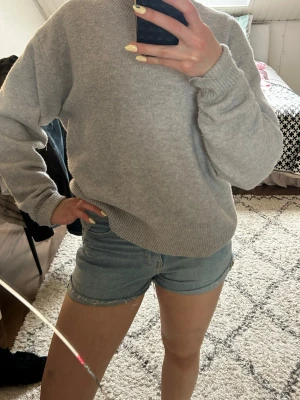 Ljusblå denimshorts med rå kant - Snygga ljusblå jeansshorts i klassisk modell med rå, fransig kant nertill. Shortsen har normal passform och är perfekta för varma dagar. Har en enkel design utan extra detaljer.
