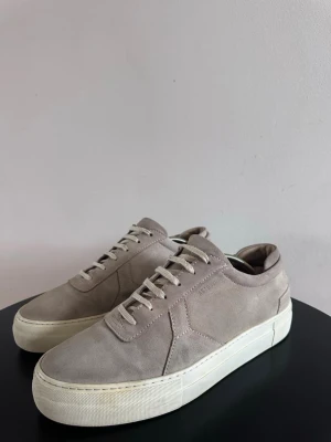 Beiga Axel Arigatos  - Fräscha och snygga sneakers från Axel Arigato. Perfekt nu till sommarn! Högra skon är lite missfärgad, se bild. Pris kan diskuteras. Hör av dig vid frågor! 