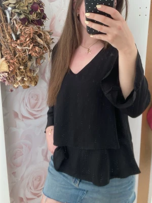 Svart volangblus från Cream - Snygg svart blus från Cream med v-ringning och volangdetaljer nertill. Blusen har trekvarts ärmar❣️