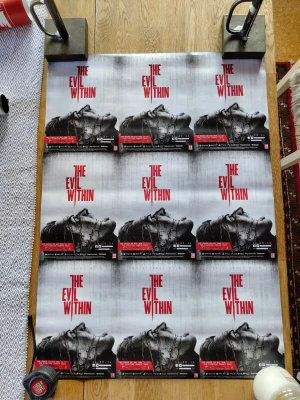 The Evil Within spelaffischer - Stor affisch för spelet The Evil Within med skräcktema. Affischen är i svart, vitt och rött med en dramatisk bild på en person och spelets logotyp. Perfekt för dig som gillar skräckspel och vill ha något snyggt på väggen.  Måttet på affischen är 54,5x84 cm.  Finns små skavanker i hörnen men inget som stör motivet.