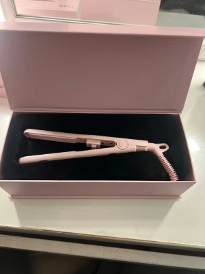 Rosa plattång från Lyko - Säljer en stilren rosa plattång med lång sladd och smal design från Lyko. Funkar helt perfekt. Använd 2 gånger ungefär!