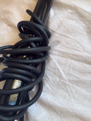 Svart locktång från Babyliss  - Säljer en svart locktång från Babyliss med sladd. Tången har en smal, rund form som passar för att skapa definierade lockar. Materialet är blankt och tåligt, och sladden är lång och flexibel för enkel styling.