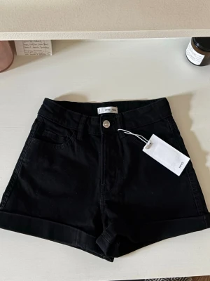 Svarta shorts från mango  - Snygga svarta shorts från mango. Gjorda i mjuk bomull med uppvikta benslut och knappstängning framtill. 