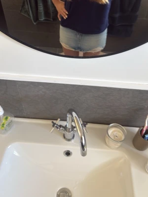 Ljusblå jeanskjol med rå kant - Trendig ljusblå jeanskjol med rå, fransad kant nertill. Klassisk femficksmodell och normal passform. Perfekt för dig som vill ha en enkel men snygg denimlook till sommaren.