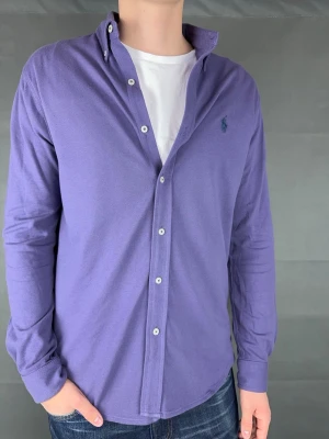 Ralph lauren skjorta - Ralph Lauren Skjorta Märke: Polo Ralph Lauren Storlek: M Passform: Slimfit Färg: Lila Skick: Mycket bra Beskrivning: feathermesh-skjorta utan defekter. Modellen på bilden: 183 cm / 75 kg