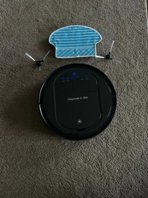 Cleanmate S 1000 robotdammsugare - Säljer en svart, rund robotdammsugare Cleanmate S 1000. Den styrs via app, kontroll eller knappar och kommer med två nya sidoborstar samt ny moppduk. Laddstation medföljer. Perfekt för smidig städning av hemmet.