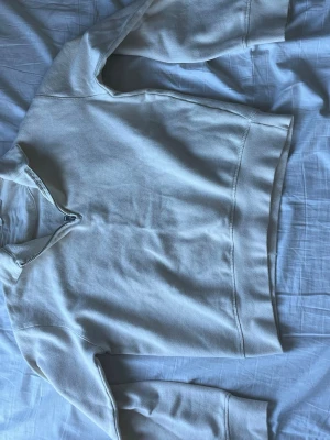 Beige hoodie med dragkedja från ZARA - Säljer en beige hoodie från ZARA med halv dragkedja framtill. Tröjan är tillverkad i ett mjukt och strukturerat material och har långa ärmar samt ribbade muddar. Perfekt för en avslappnad och cool look. Priset kan såklart alltid diskuteras