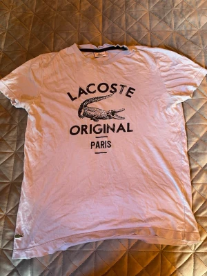 Lacoste T-shirt  - Riktigt snygg Lacoste T-shirt, storlek M men passar S (mått kan fås om de önskas) trycket på tröjan är ej slitet, det är designen på tröjan😊 pris kan diskuteras🙌🏼