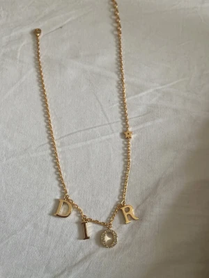Guldhalsband med bokstäver och diamanter  - Snyggt guldhalsband 18k. Kedjan har en liten stjärndetalj och bokstaven O är dekorerad med små gnistrande stenar. Perfekt accessoar för dig som gillar exklusiva smycken och vill sticka ut. (Copy)