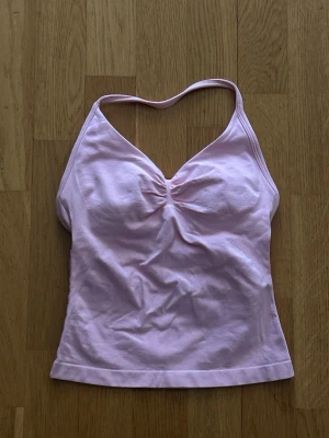 DFYNE Impact Longline Strappy Top - Säljer en DFYNE Impact Longline Strappy Top i färgen ”Light Rose Pink” med inbyggd sport-bh i st XS, endast använd fåtal gånger hemma då den är för liten vid brösten. Original pris 52,95€ - ca 580kr. Finns orderbekräftelse och DFYNE-tag bak om man vill se för äkthets bevis!!