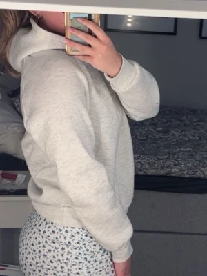 Ljusgrå hoodie med huva - En enkel och stilren ljusgrå hoodie med huva och långa ärmar. Hoodien har en klassisk passform och ribbade muddar vid ärmslut och nederkant. Perfekt för en avslappnad och bekväm look. Materialet är mjukt o skönt. Den är dock lite knopprig något man inte ser på bilderna men de går att lösa. Djur finns i hemmet, tvättas innan leverans.🌸
