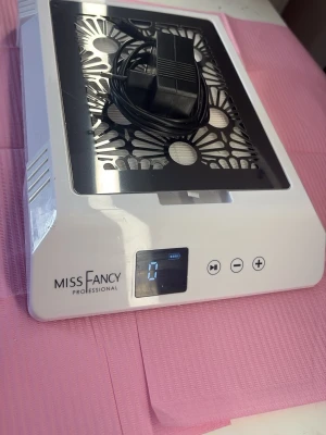 Utsug Miss Fancy - Elektrisk nageldammsugare från Miss Fancy Professional i vit plast med svart metallgaller och digital display. Perfekt för att hålla nagelstationen fri från damm vid manikyr och nagelförlängning. Kommer med strömadapter.
