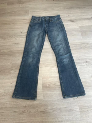 Blå bootcut jeans med slitningar - Snygga blå lågmidjade bootcut jeans. Säljer pågrund av datt de tyvvär är för små för mig. De är lite smått slitna längst ner men det är inget man lägger så mycket märke till💕.